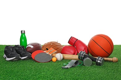 Photo of Different sport equipment on green grass against white background