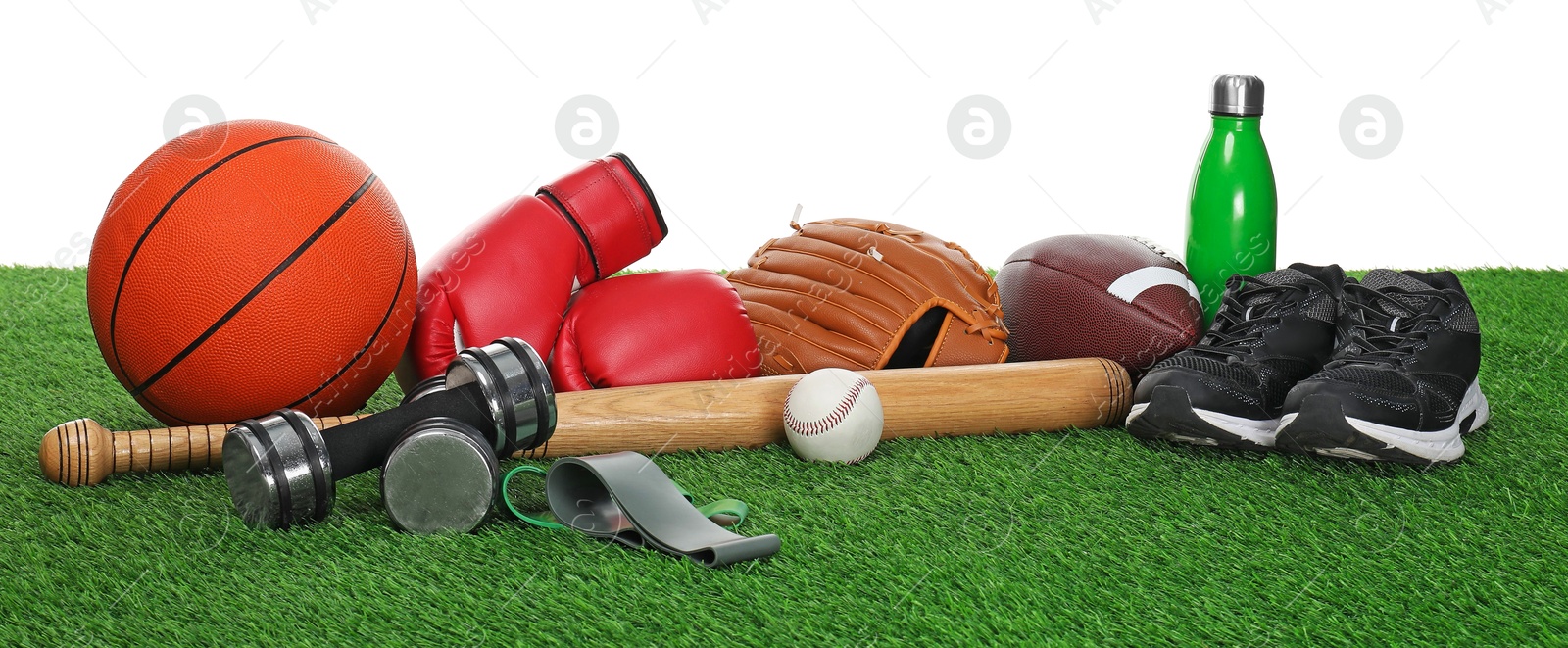 Photo of Different sport equipment on green grass against white background