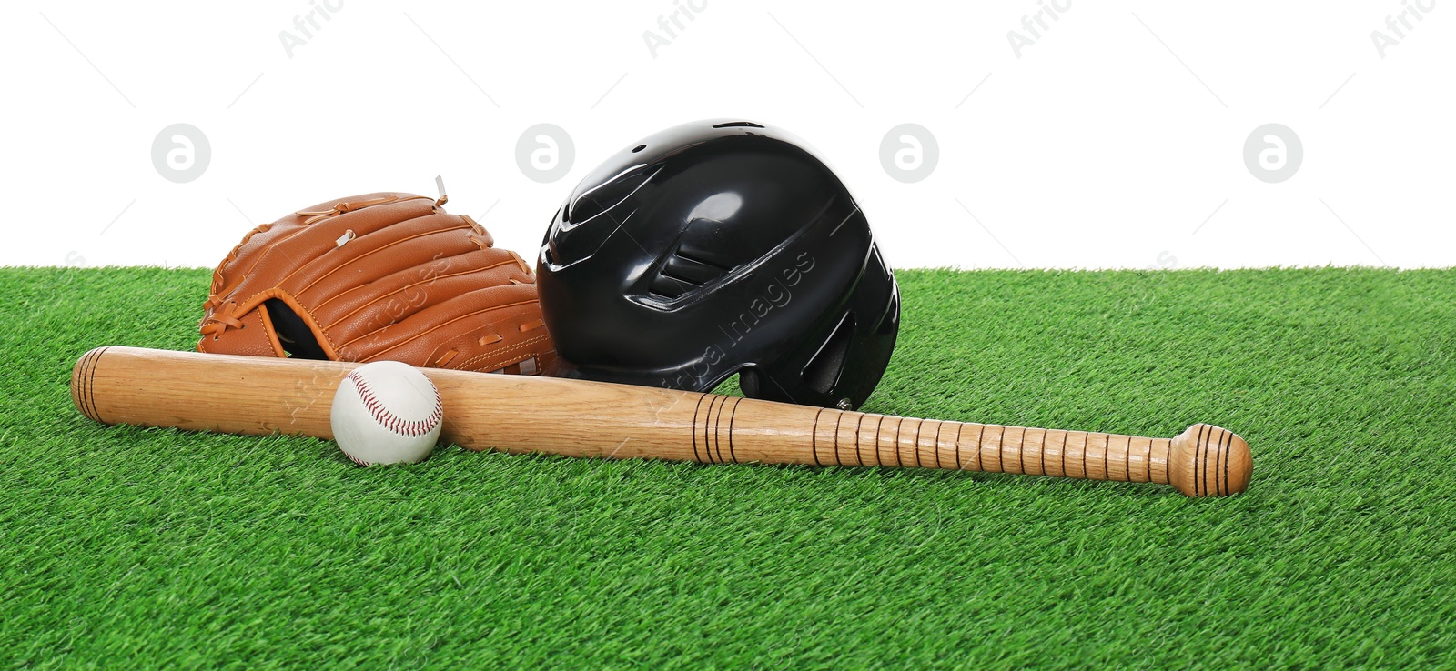 Photo of Baseball bat, ball, helmet and glove on green grass against white background. Sport equipment