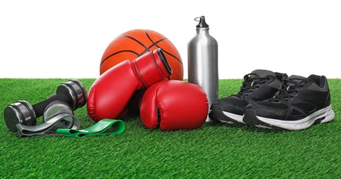 Photo of Different sport equipment on green grass against white background