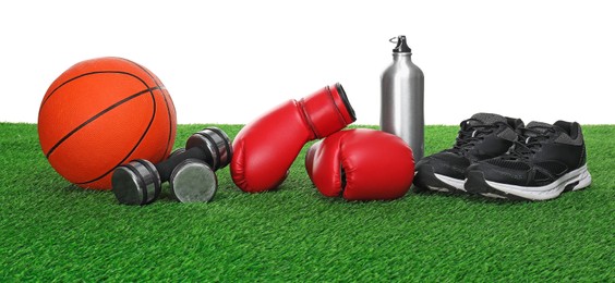 Photo of Different sport equipment on green grass against white background