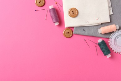 Photo of Different sewing supplies on pink background, flat lay. Space for text