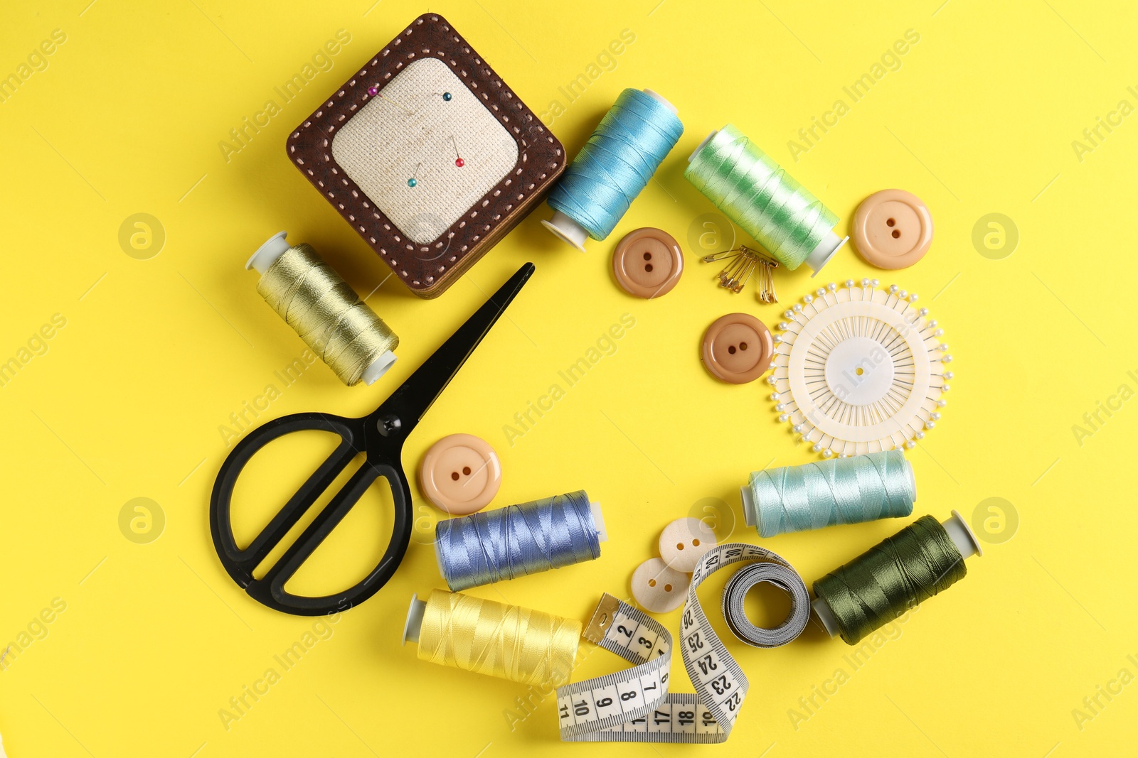 Photo of Frame made of different sewing supplies on yellow background, flat lay. Space for text