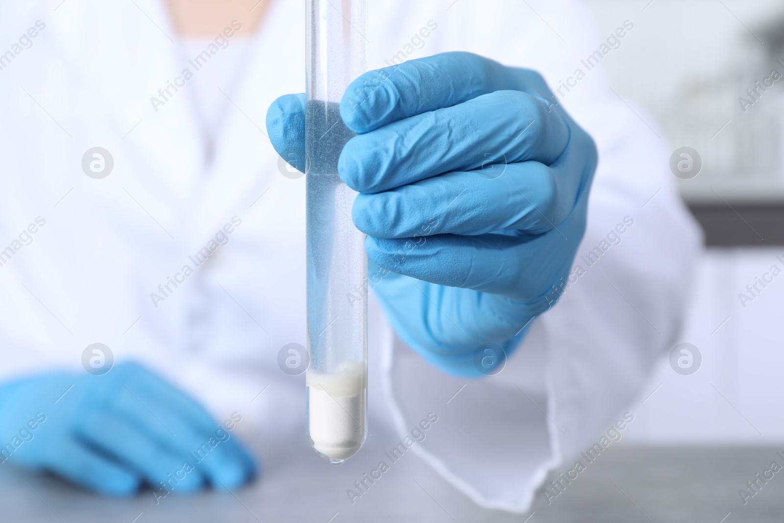 Photo of Laboratory testing. Scientist with test tube of sample indoors, closeup