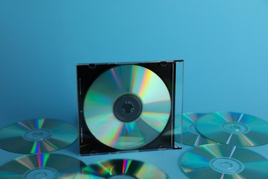 Photo of Many compact discs on light blue background