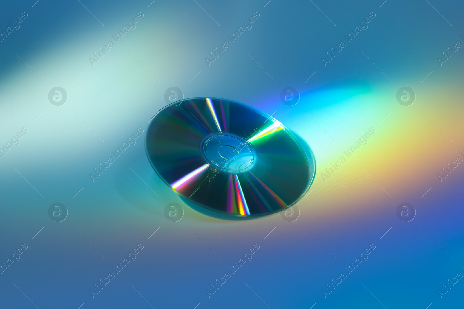 Photo of One shiny compact disc on light blue background