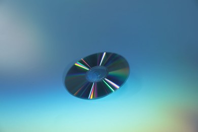 Photo of One shiny compact disc on light blue background