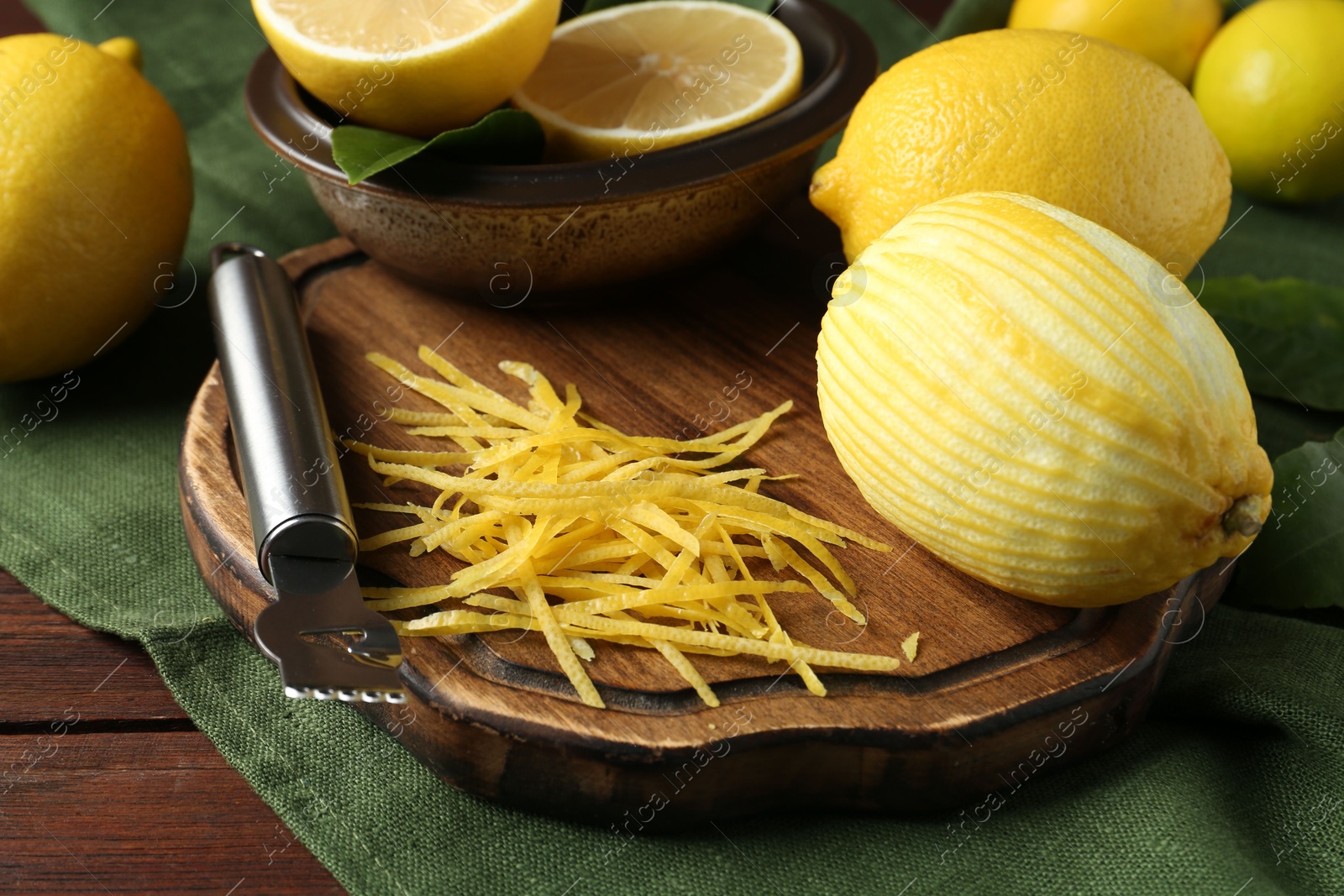 Photo of Lemon zest, zester tool and fresh fruits on wooden table, closeup