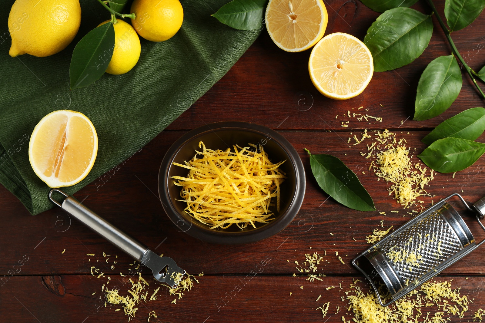 Photo of Lemon zest, tools and fresh fruits on wooden table, flat lay