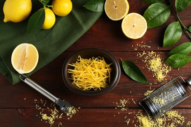 Photo of Lemon zest, tools and fresh fruits on wooden table, flat lay