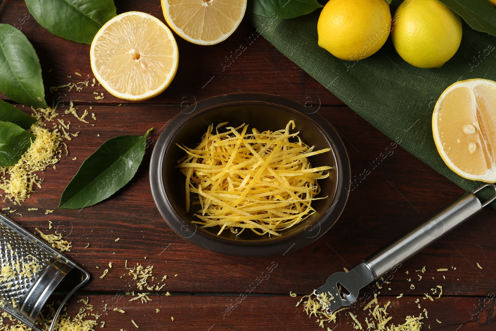 Photo of Lemon zest, tools and fresh fruits on wooden table, flat lay