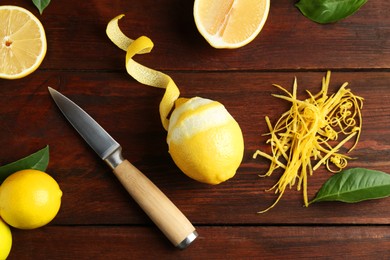 Photo of Lemon zest, knife and fresh fruits on wooden table, flat lay