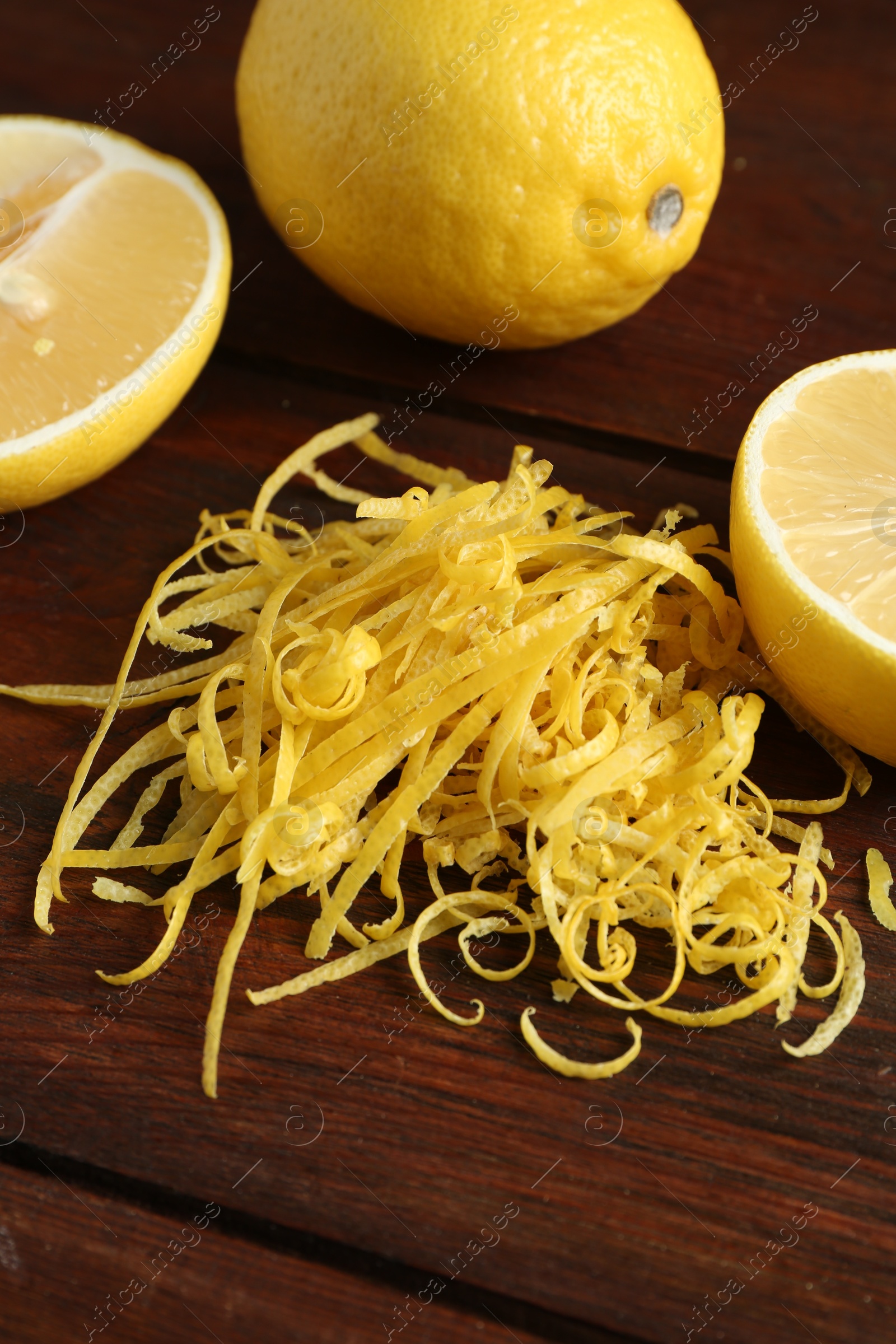 Photo of Lemon zest and fresh fruits on wooden table, closeup