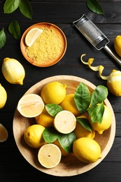 Photo of Lemon zest, grater and fresh fruits on black wooden table, flat lay