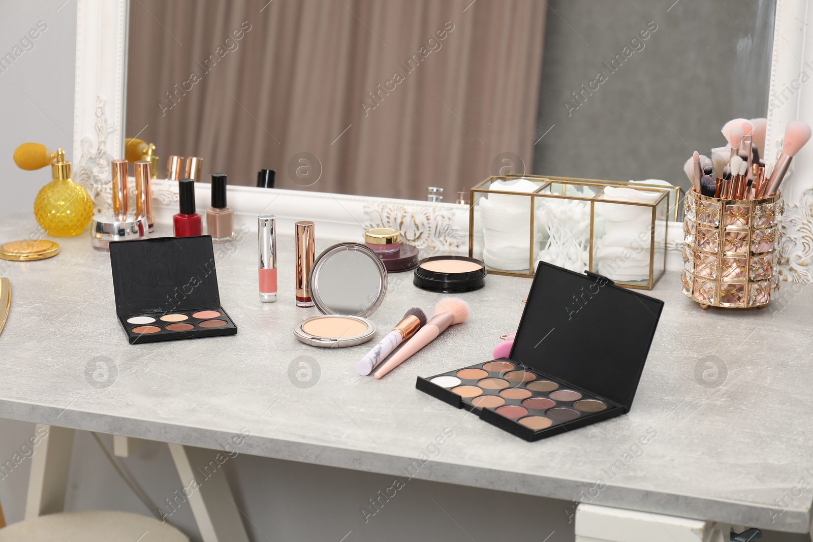 Photo of Makeup room. Different beauty products on dressing table and mirror indoors