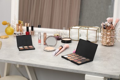 Photo of Makeup room. Different beauty products on dressing table and mirror indoors