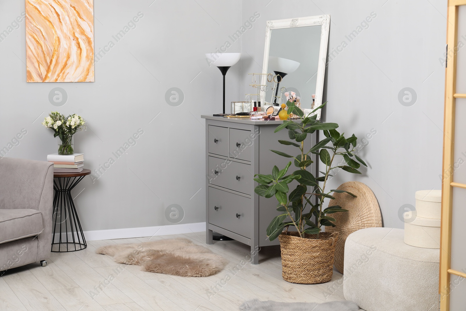 Photo of Makeup room. Mirror, dresser, different beauty products and houseplant indoors