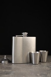 Photo of Hip flask, cups and funnel on grey table