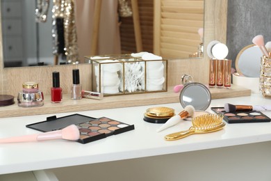 Photo of Makeup room. Different beauty products on white dressing table and mirror indoors