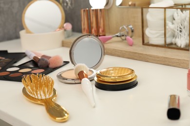 Photo of Makeup room. Different beauty products on white dressing table, closeup