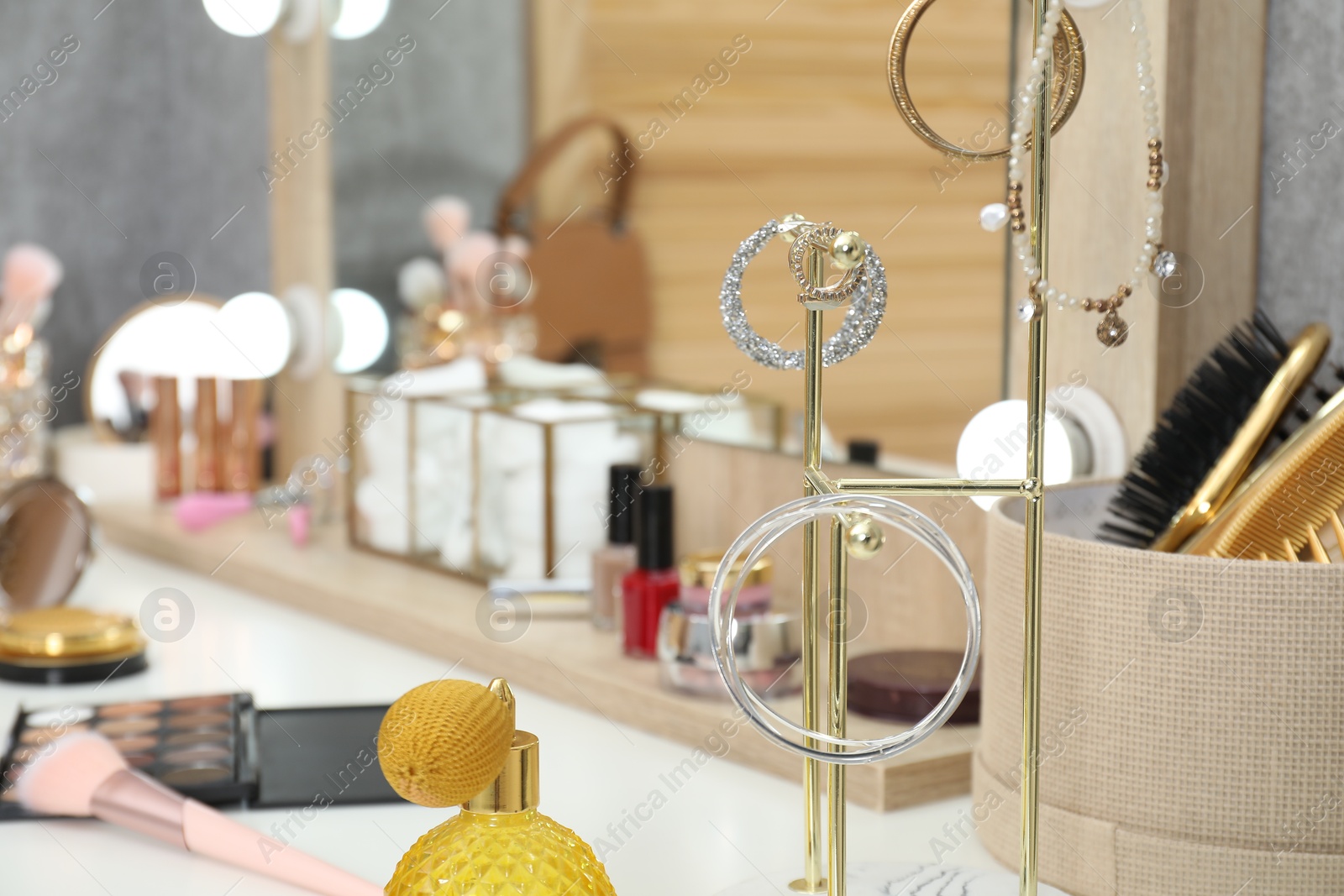 Photo of Makeup room. Jewelry and different beauty products on dressing table indoors, closeup