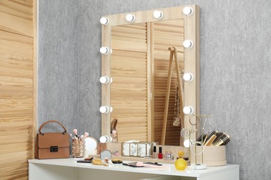 Photo of Makeup room. Mirror, dressing table and different beauty products indoors