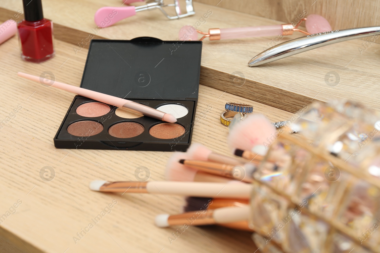 Photo of Makeup room. Different beauty products on wooden dressing table, closeup