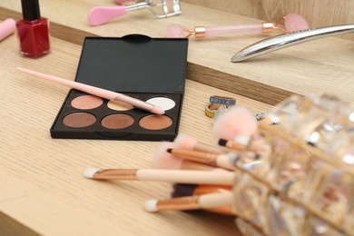 Photo of Makeup room. Different beauty products on wooden dressing table, closeup