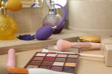 Photo of Makeup room. Different beauty products on wooden dressing table, closeup