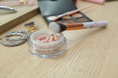 Photo of Makeup room. Different beauty products and jewelry on wooden dressing table, closeup