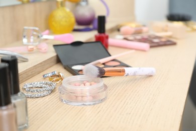 Photo of Makeup room. Different beauty products and jewelry on wooden dressing table, closeup