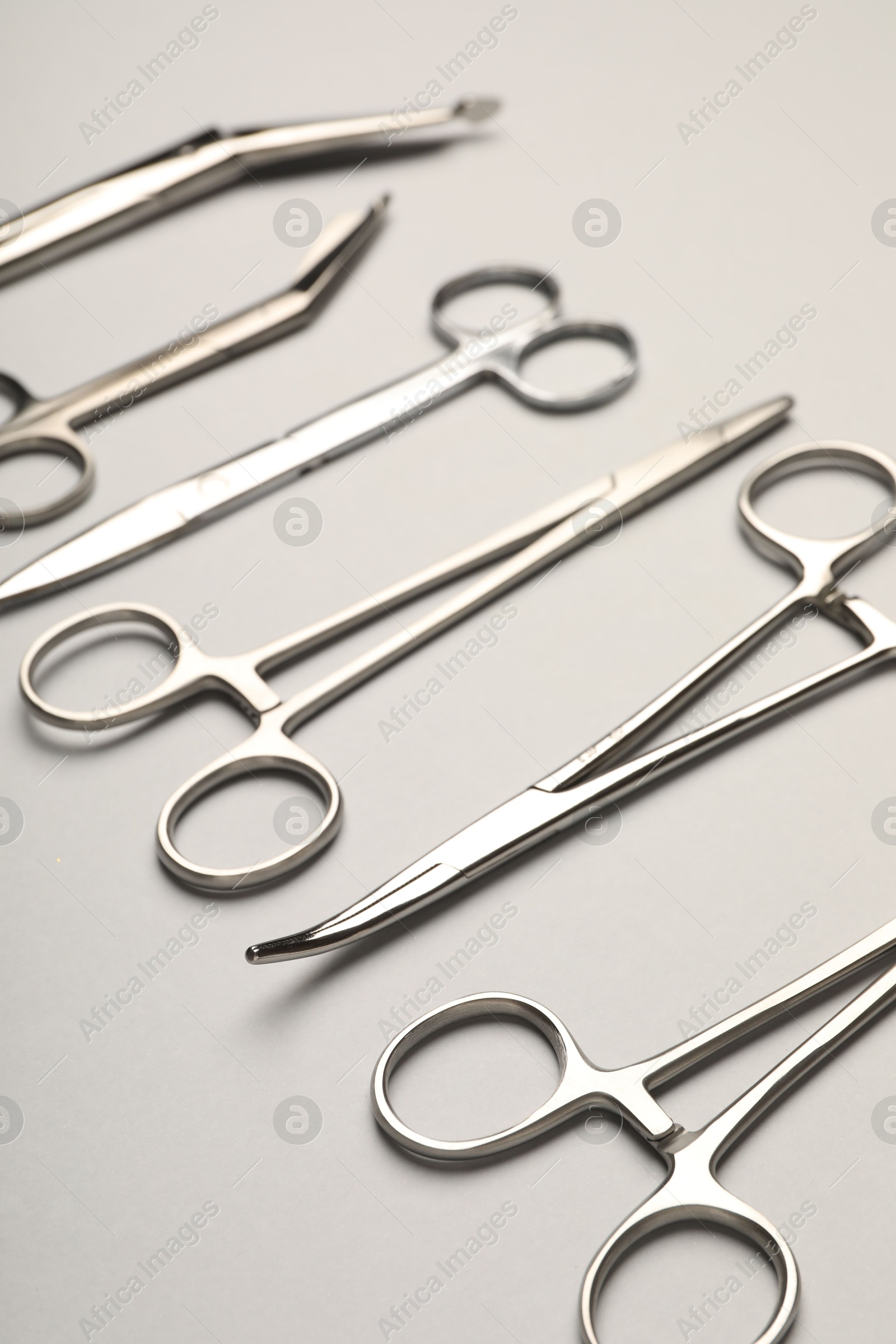 Photo of Different surgical instruments on grey background, closeup