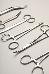 Photo of Different surgical instruments on grey background, closeup