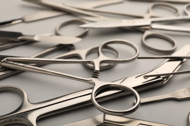 Photo of Different surgical instruments on grey background, closeup