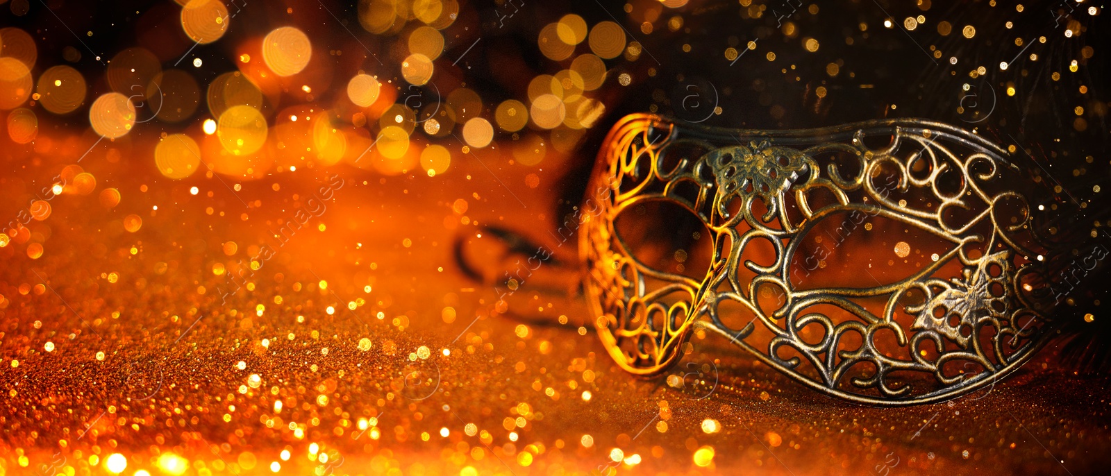 Image of Beautiful carnival mask on black background with glitter, bokeh effect. Banner design with space for text