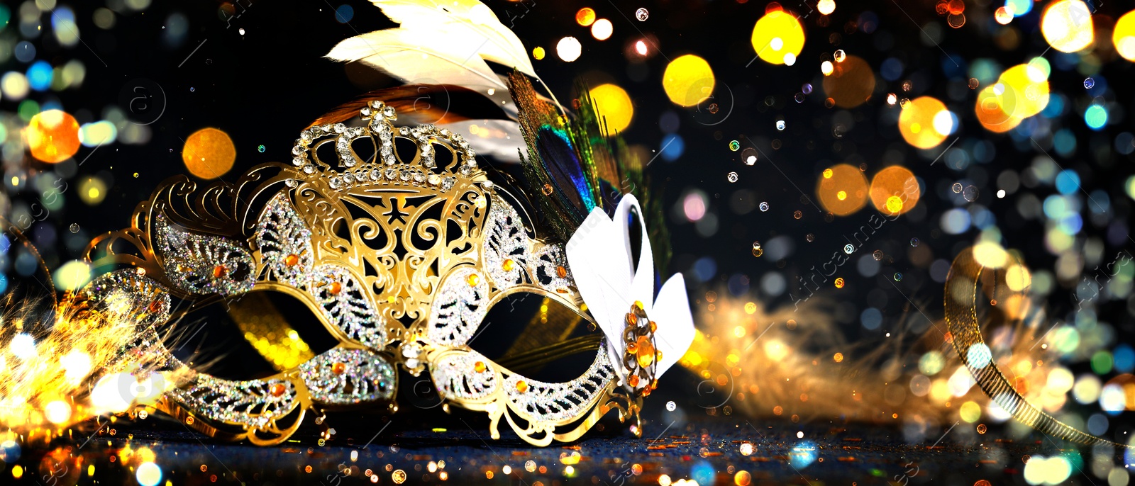 Image of Beautiful carnival mask on black background with glitter, bokeh effect. Banner design with space for text