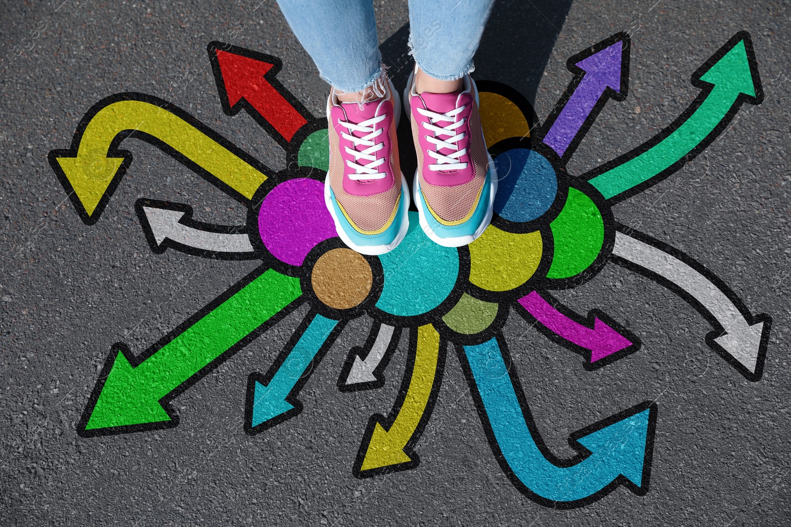 Image of Woman standing on asphalt road with colorful arrows pointing in different directions, top view. Concept of choice and making decisions