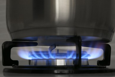 Photo of Pot on modern gas cooktop in kitchen, closeup