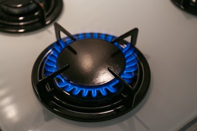 Photo of Modern kitchen stove with burning gas, above view