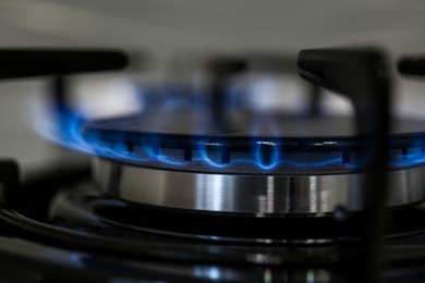 Photo of Modern kitchen stove with burning gas, closeup