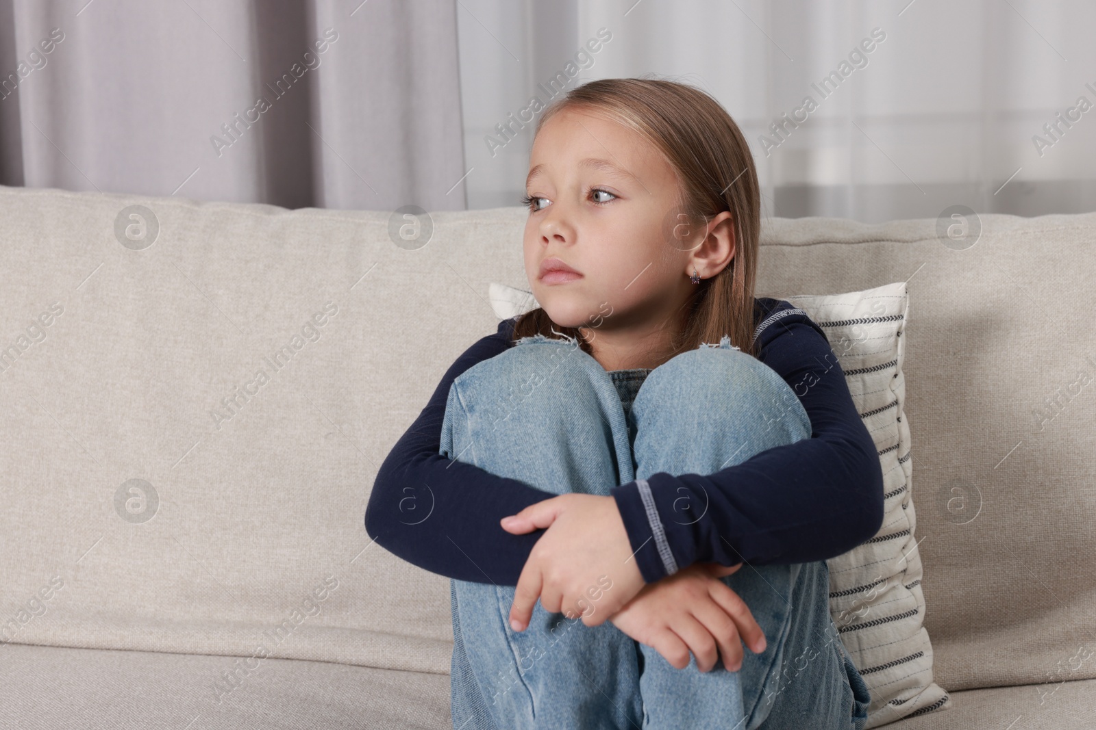 Photo of Autism concept. Lonely little girl on sofa at home