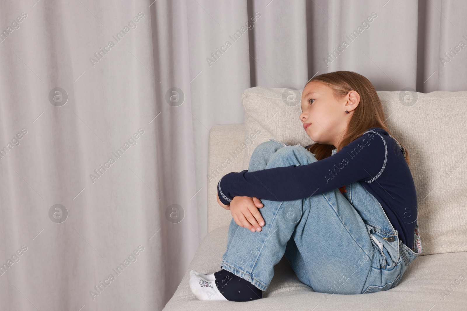 Photo of Autism concept. Lonely little girl on sofa at home, space for text