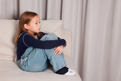 Photo of Autism concept. Lonely little girl on sofa at home, space for text