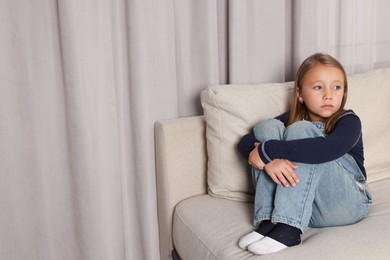 Photo of Autism concept. Lonely little girl on sofa at home, space for text