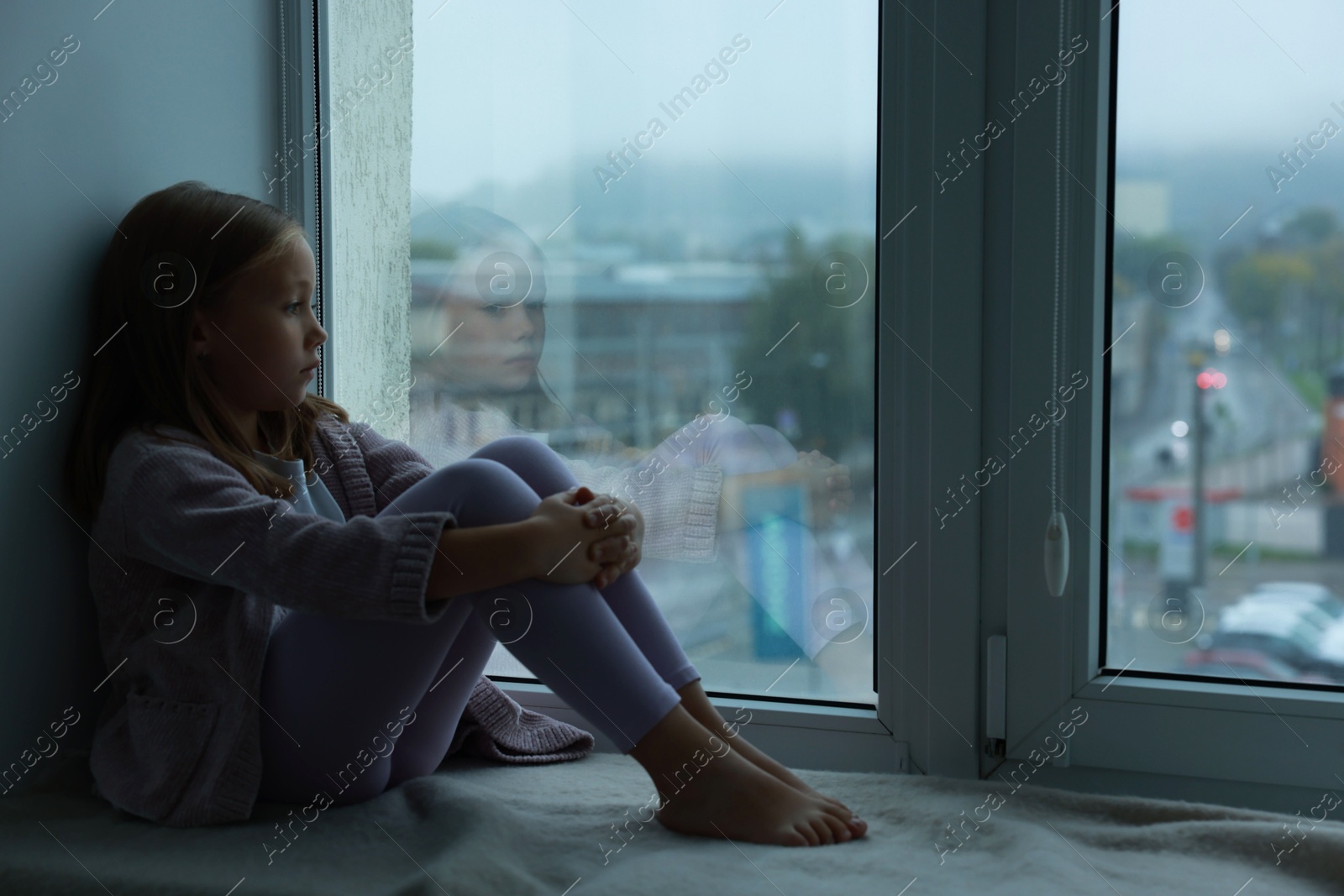 Photo of Autism concept. Lonely little girl near window at home