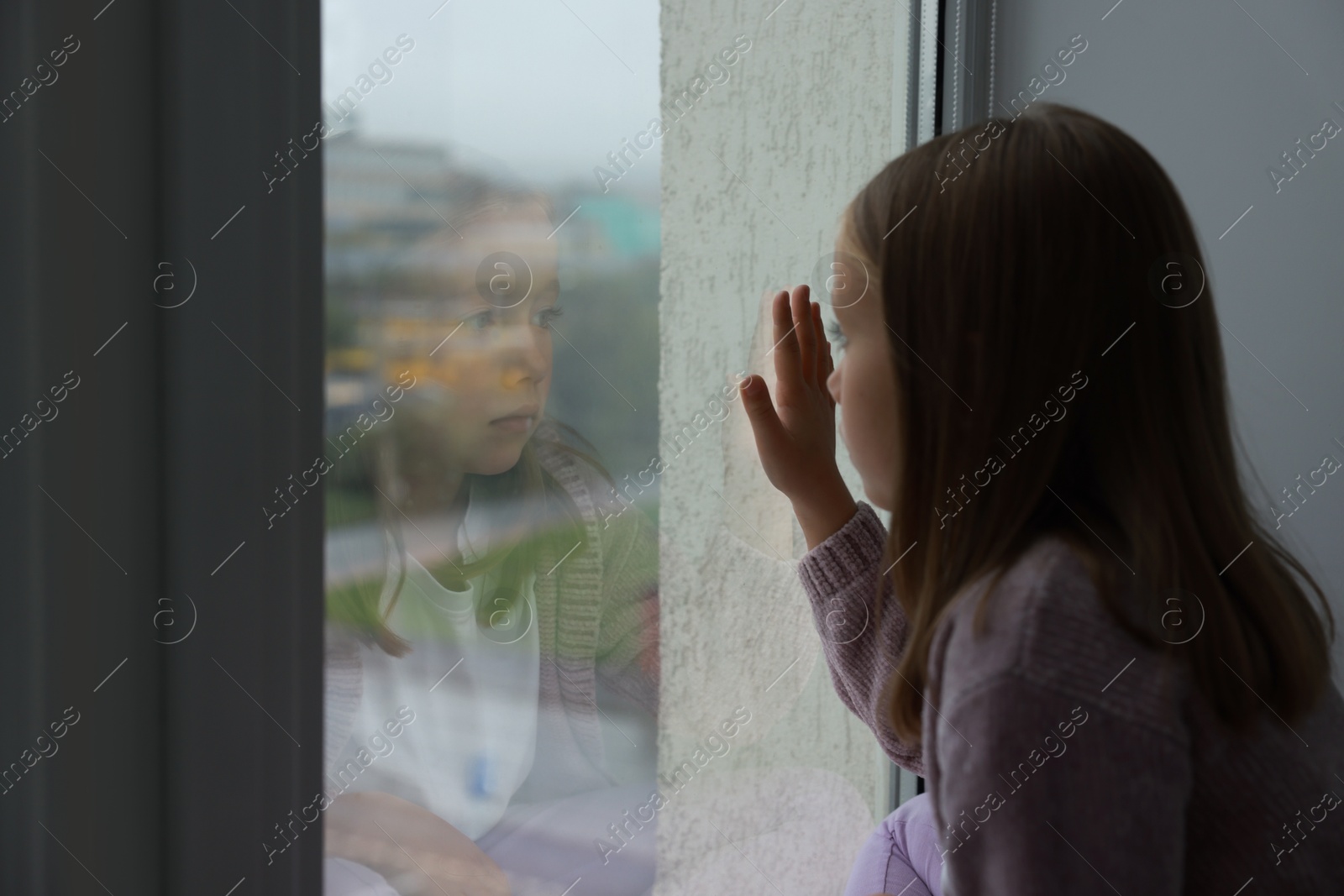 Photo of Autism concept. Lonely little girl near window at home