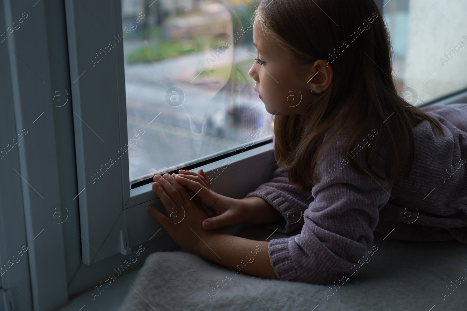 Photo of Autism concept. Lonely little girl near window at home