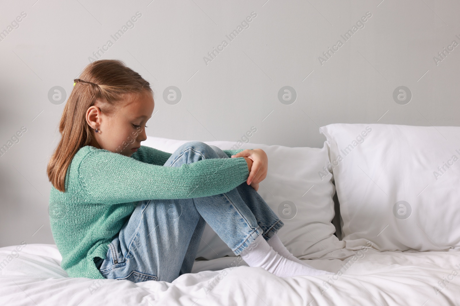 Photo of Autism concept. Lonely little girl on bed at home