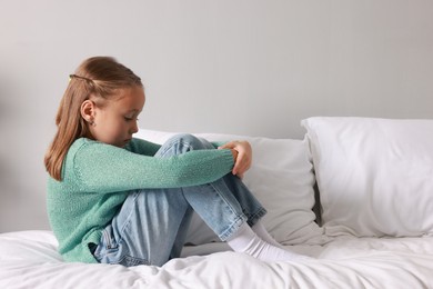 Photo of Autism concept. Lonely little girl on bed at home