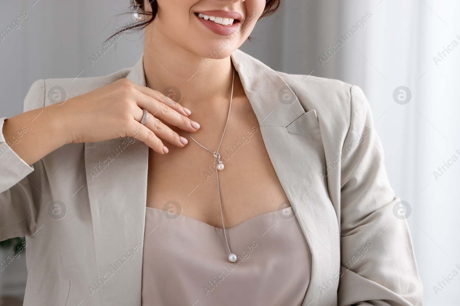 Photo of Young woman wearing elegant jewelry indoors, closeup